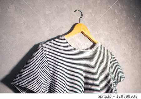 T-shirt on hanger. View from below. Basic female clothes on everyday. T-shirt on hanger. View from below. Basic female clothes on everyday. 129599938