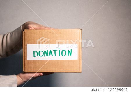 Woman preparing old clothes for charity. Clothes donation concept. Second hand shop. Woman preparing old clothes for charity. Clothes donation concept. Second hand shop. 129599941