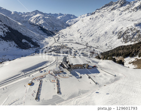 Flight over the famous village of Andermatt in Switzerland in winter - aerial photography 129601793