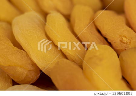 dried pitted apricots are yellow in color, a lot of dried apricots are dehydrated after removing the seeds, side view 129601893