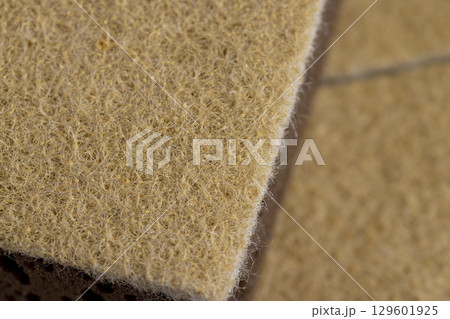 glued and tightly intertwined synthetic sand-colored threads on a sponge that is used for cleaning and washing, closeup glued and tightly intertwined synthetic sand-colored threads on a sponge that is used for cleaning and washing, closeup 129601925