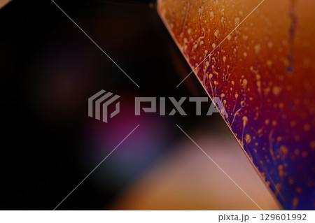 Bright multicoloured liquid surface on black background, interference pattern 129601992