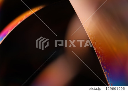 Bright multicoloured liquid surface on black background, interference pattern 129601996