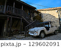 Rusty abandoned car in the parking lot of an abandoned house. Retro car 129602091