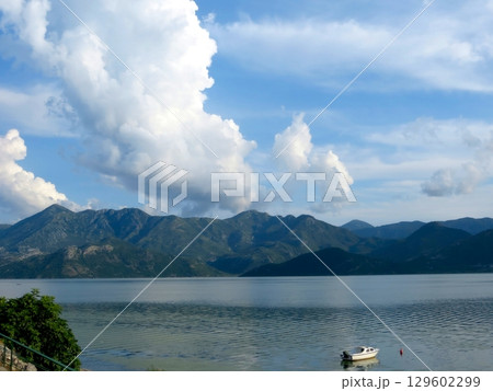 Enjoying a Serene Boat Ride on Skadar Lake, Surrounded by Breathtaking Mountains Enjoying a Serene Boat Ride on Skadar Lake, Surrounded by Breathtaking Mountains 129602299