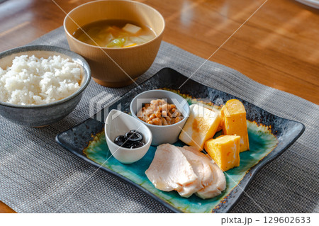 卵焼きや納豆、鶏ハムなどが並ぶ和風の健康的な朝食セット 129602633