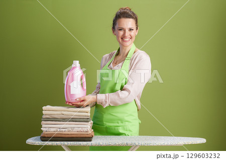 Smiling woman holding laundry detergent bottle Smiling woman holding laundry detergent bottle 129603232