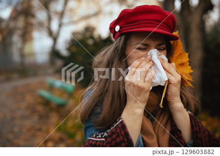 stylish 40 years old woman in red hat blowing nose stylish 40 years old woman in red hat blowing nose 129603882