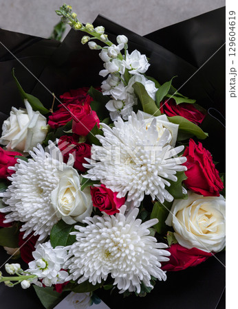 a beautiful bouquet featuring a combination of red roses and white chrysanthemums. a beautiful bouquet featuring a combination of red roses and white chrysanthemums. 129604619