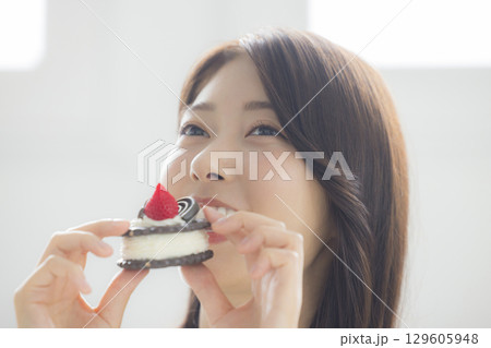 ケーキを食べる若い女性　 129605948
