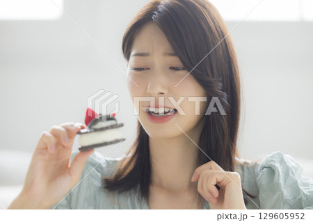 ケーキを食べる若い女性　 129605952