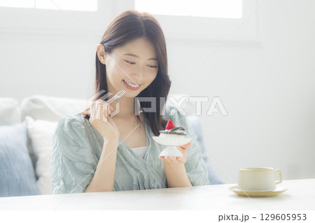 ケーキを食べる若い女性　 129605953