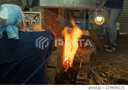 日本独自の鍛錬方法で作られる日本刀を鍛えている鍛冶屋の職人を撮影 日本独自の鍛錬方法で作られる日本刀を鍛えている鍛冶屋の職人を撮影 129606131