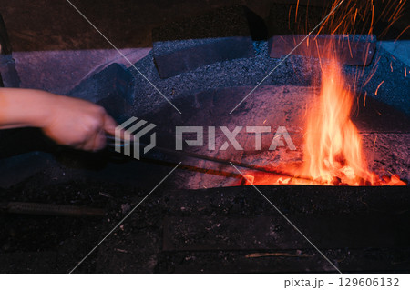 日本独自の鍛錬方法で作られる日本刀を鍛えている鍛冶屋の職人を撮影 日本独自の鍛錬方法で作られる日本刀を鍛えている鍛冶屋の職人を撮影 129606132