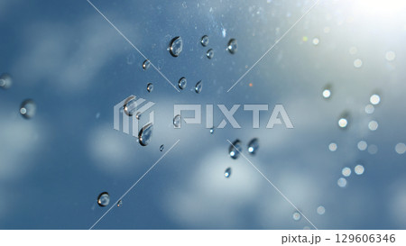 water drop on mirror with blue sky and white cloud background 129606346