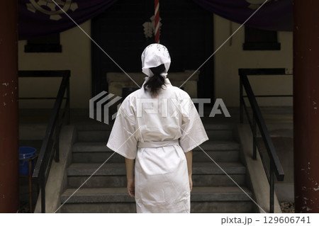 滝行前に神社でお参りをする白衣姿の女性 129606741