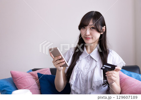 スマホでオンラインショッピングを楽しむ笑顔の日本人女性 129607189