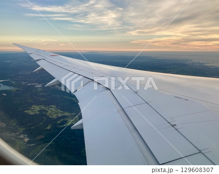 飛行機の窓から見る夕焼け空 129608307