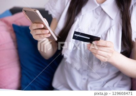 スマホでオンラインショッピングをする日本人女性の手元 129608471