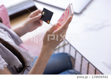 スマホでオンラインショッピングをする日本人女性の手元 129608482