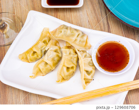 Appetizing steamed dumplings gyoza with soy dipping sauce 129608706