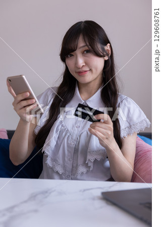 スマホでオンラインショッピングを楽しむ日本人女性 129608761