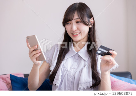 スマホでオンラインショッピングを楽しむ日本人女性 129608875