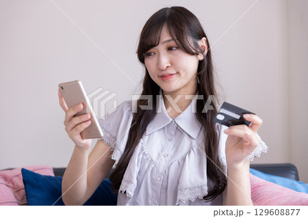 スマホでオンラインショッピングを楽しむ日本人女性 129608877