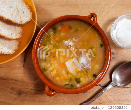 Popular dish of Russian cuisine is pickle soup with meat, cooked on basis of pickled cucumbers and pearl barley closeup 129608892