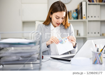 Woman office worker with wage packet 129609177