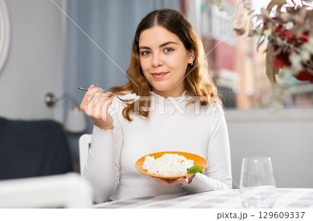 Positive woman eating portion of boiled rice at home Positive woman eating portion of boiled rice at home 129609337