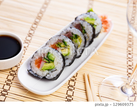Set of japanese rolls futomaki with soy and chili sauces close up 129609375