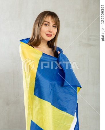 Smiling female fan of Sweden cheers for winning holding flag Smiling female fan of Sweden cheers for winning holding flag 129609393