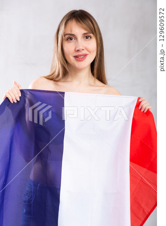 Young woman covering herself with French flag 129609572