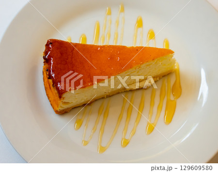 Piece of glazed cheesecake served in a plate 129609580