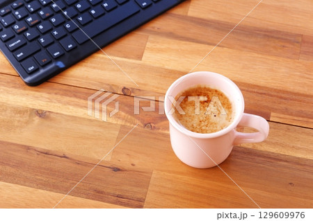 淹れたての美味しいコーヒーを飲みながら、ノートパソコンでデスクワークをしているイメージ 129609976