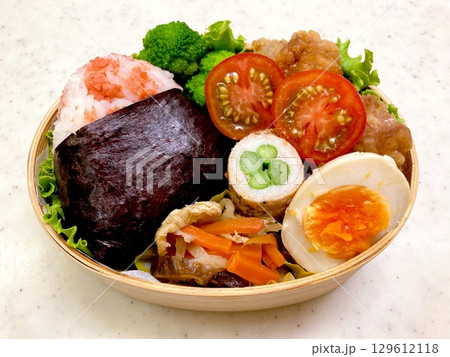 A colorful dosirak lunchbox filled with neatly arranged rice, savory protein, and assorted side dishes. A portable feast that captures the essence of authentic Korean home-style cooking. 129612118