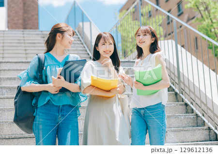 キャンパスを歩く3人の大学生 129612136