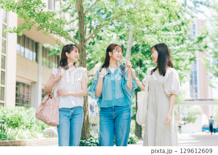 キャンパスを歩く3人の大学生 129612609