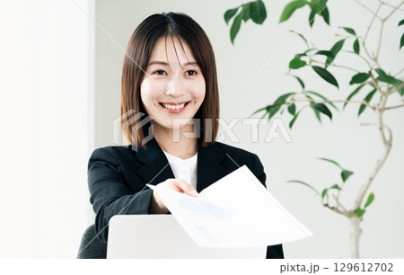 書類を手渡すビジネスウーマン 129612702