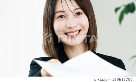 書類を手渡すビジネスウーマン 129612706