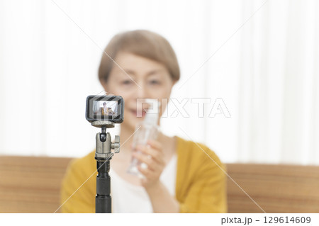 リビングで動画配信をするシニア女性 リビングで動画配信をするシニア女性 129614609