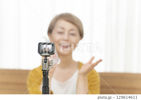 リビングで動画配信をするシニア女性 リビングで動画配信をするシニア女性 129614611