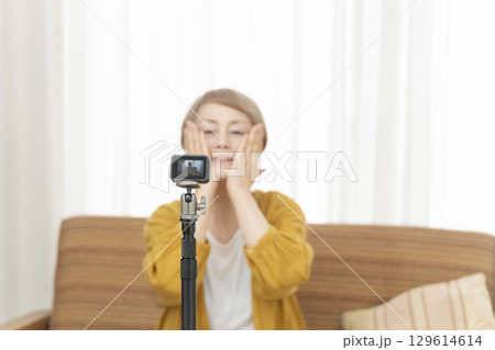 リビングで動画配信をするシニア女性 129614614