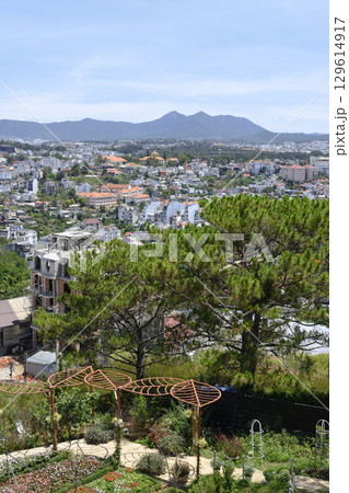 Aerial view of a city in a valley surrounded by forests with mountains on the horizon 129614917