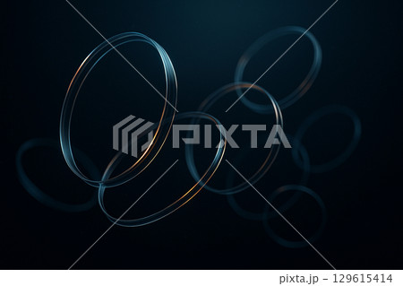 暗い空間に浮かぶブルーグレーとアンバーに輝くガラスのリング 129615414