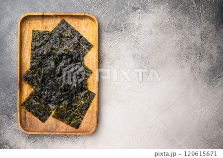 Crispy Nori seaweed sheets in a wooden tray. white background. top view 129615671