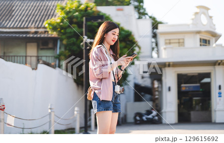 Asian woman using smartphone internet searching maps for local solo travel Asian woman using smartphone internet searching maps for local solo travel 129615692