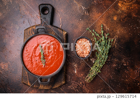 Tomato sauce passata in a skillet , traditional recipe of italian cuisine. brown background. top view 129615714