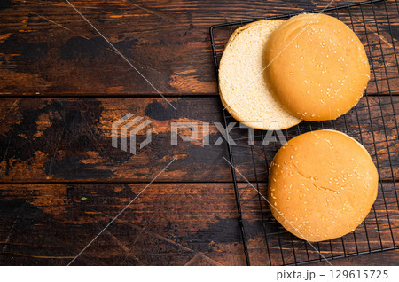 Fresh Baked burger buns, bread for cooking hamburgers. wooden background. top view 129615725